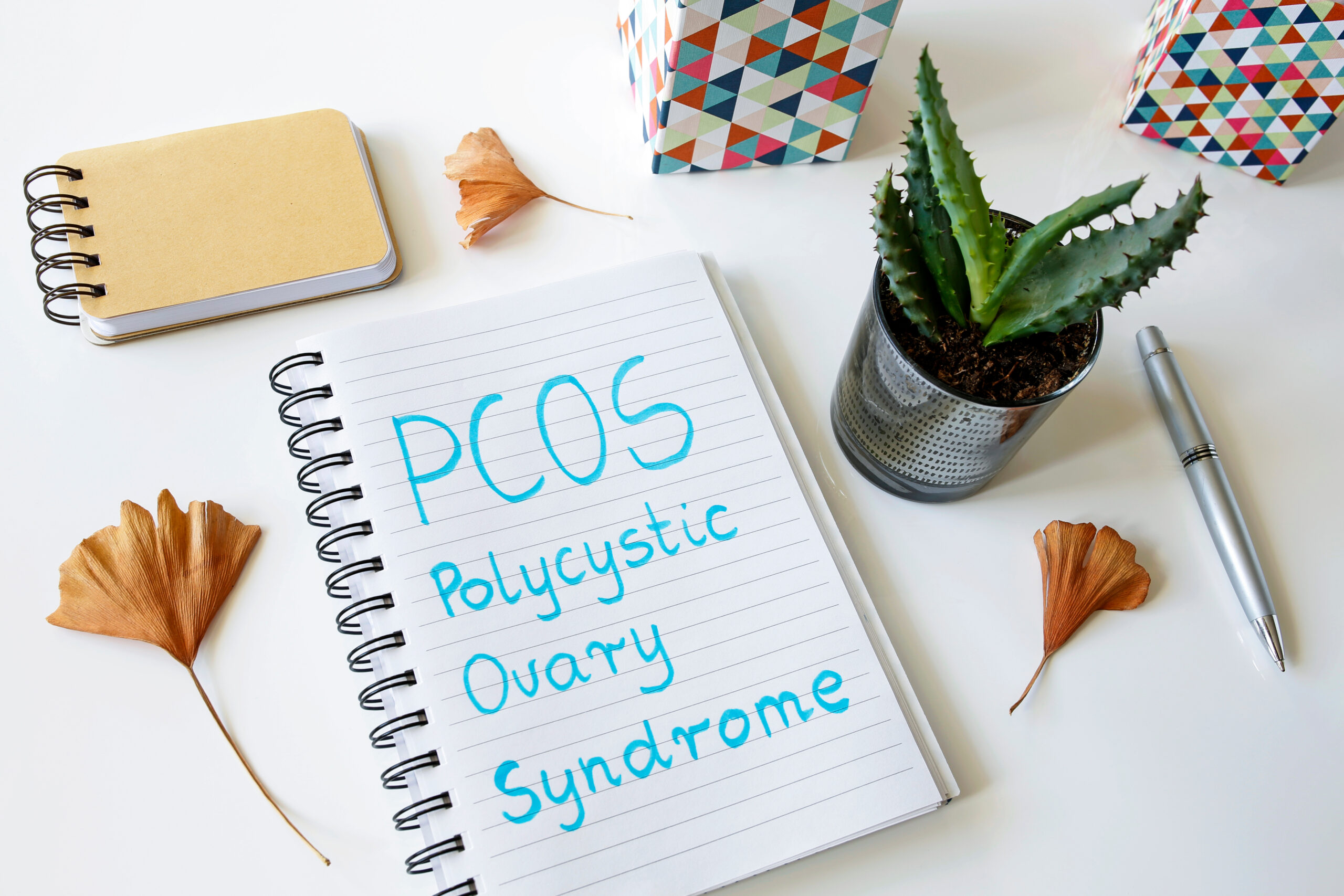 PCOS Polycystic ovary syndrome written in a notebook on white ta